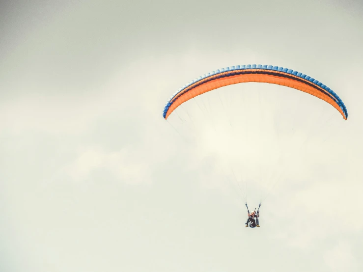 person paragliding under cloudy sky during daytime