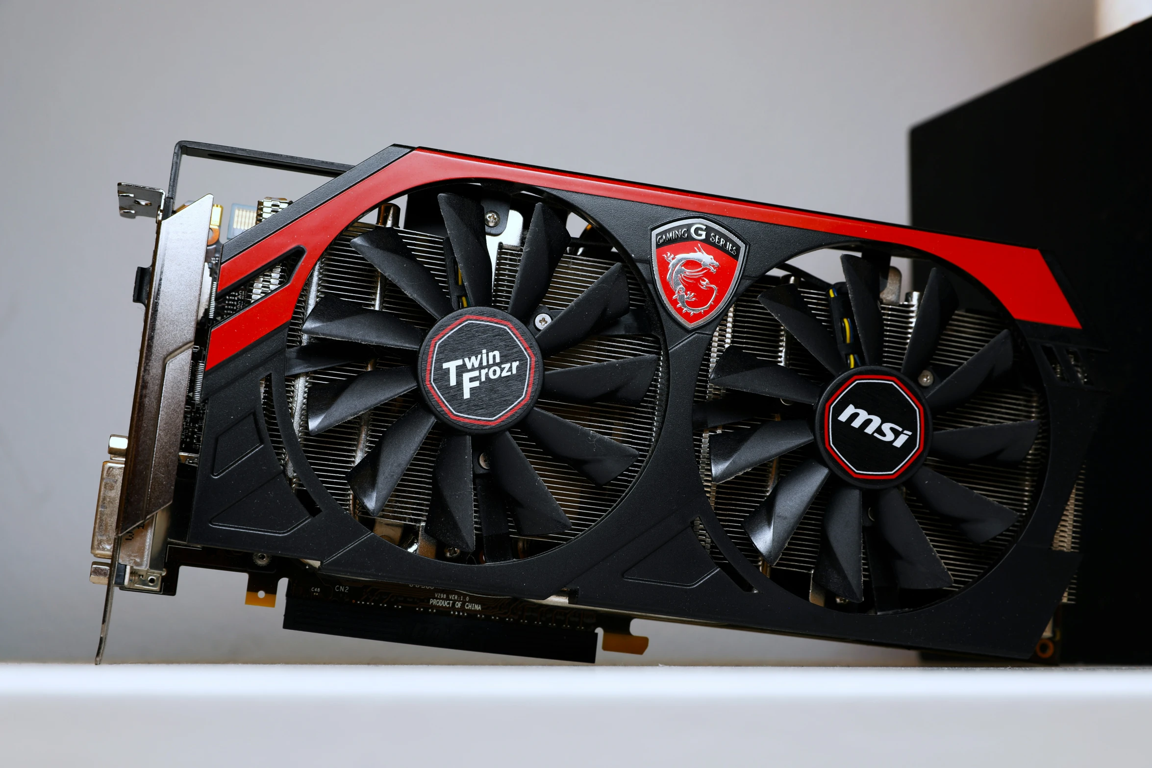 a red and black graphics card sits on top of the other