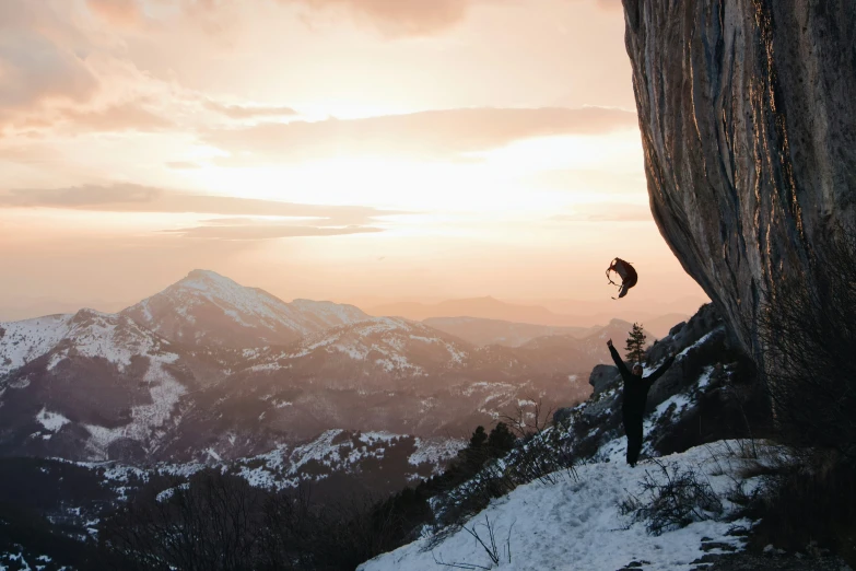 a person rapping on the side of a snowy cliff