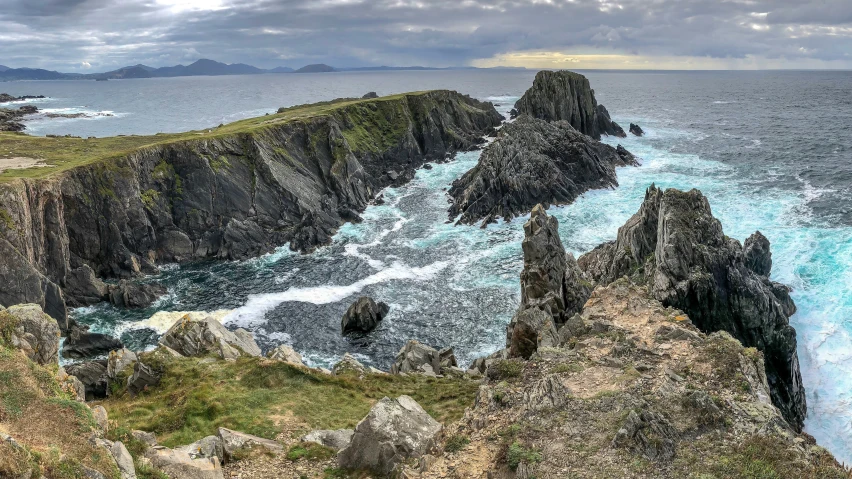 a body of water with rocks, ocean and sky