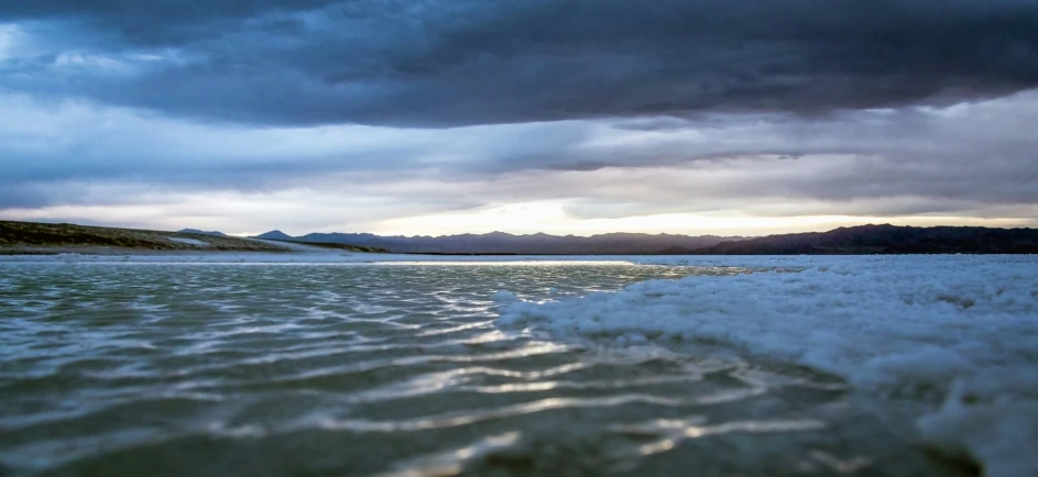 a body of water is shown under storm clouds