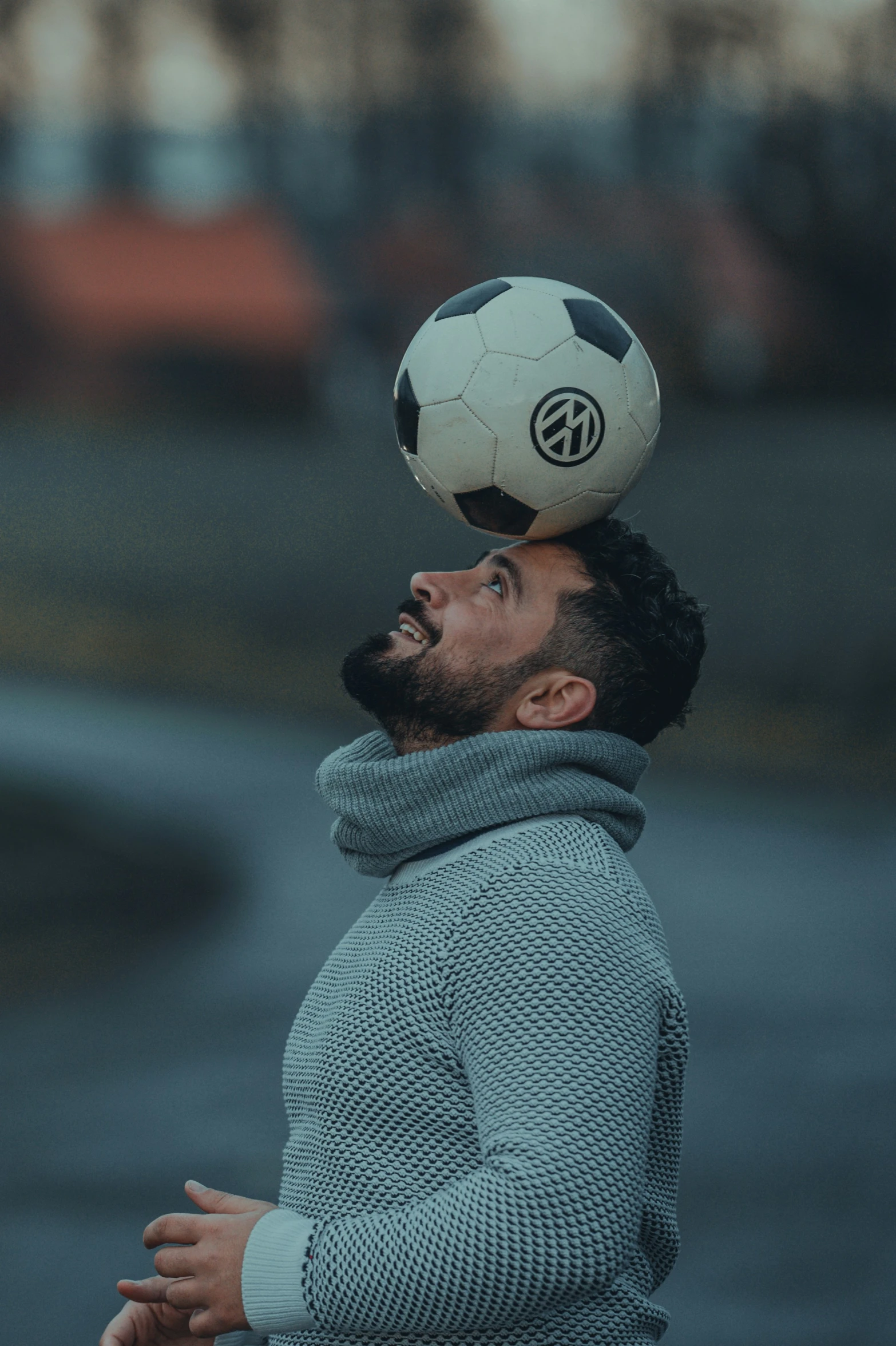 a man with a goatee and a soccer ball on his head