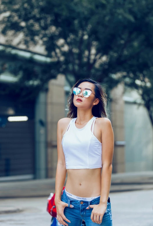 a young woman with sunglasses is standing in the street