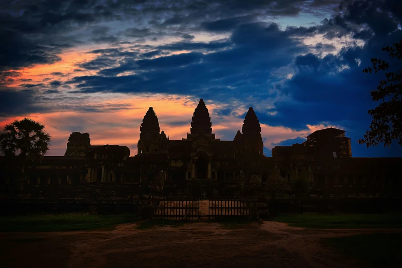 a large stone building with towers in front of clouds