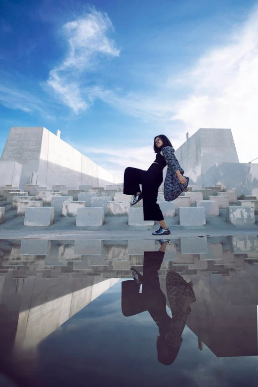 a woman dances in front of the reflecting ground