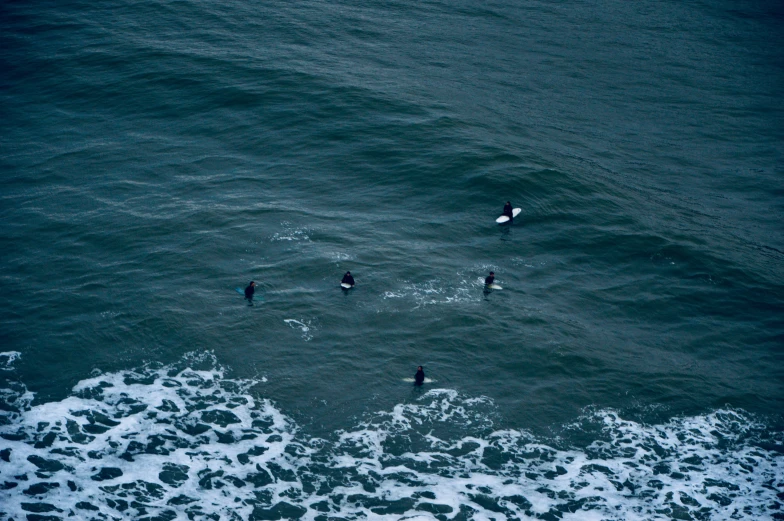 three people are wading on surfboards in the ocean
