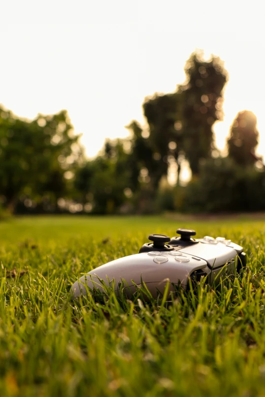 a remote controller lying in the middle of a grassy field