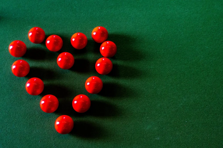 a group of balls in the shape of a heart on a pool table