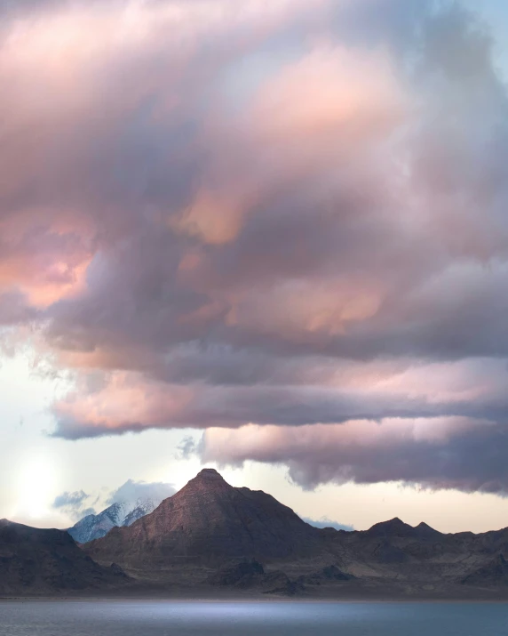 a big hill with clouds in the sky above