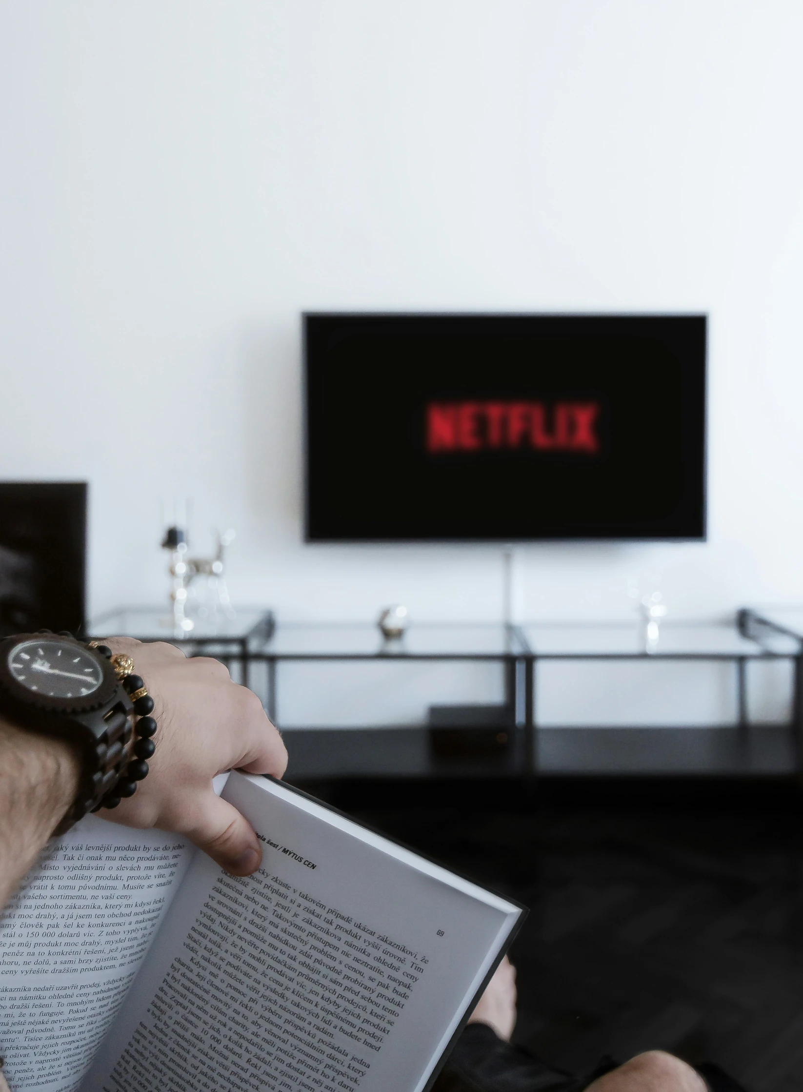 a hand holding a book over the tv