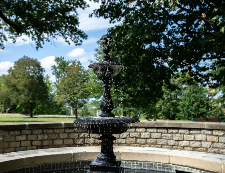 a water fountain that is next to a brick wall