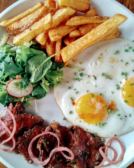 an omelette is served with a side of steak and french fries