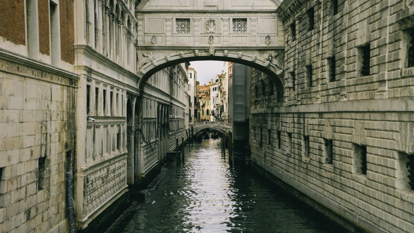 a waterway flowing under a bridge in a narrow city