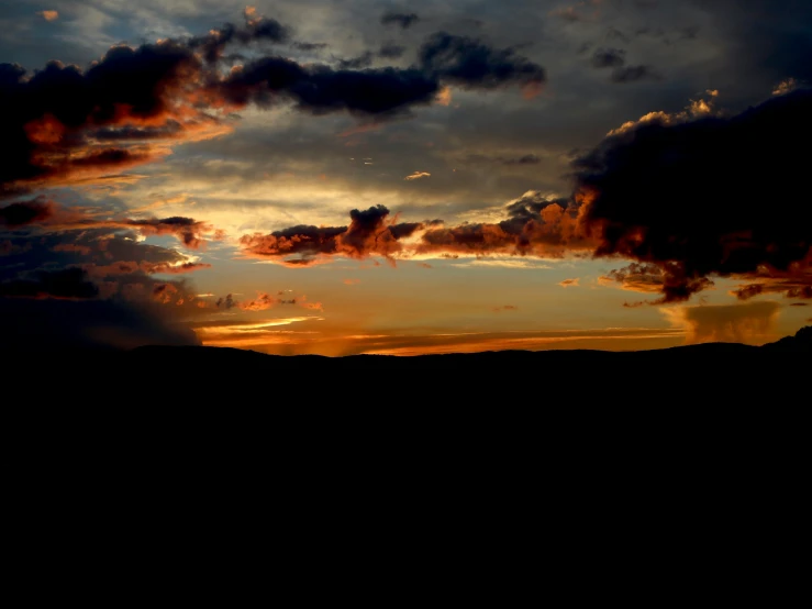 a view of a sunset behind some clouds