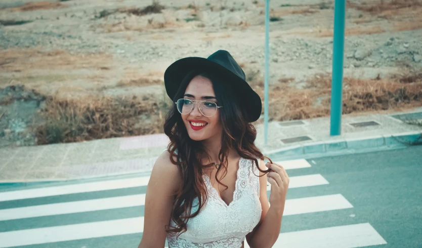 a young woman wearing glasses and a black hat poses for a po