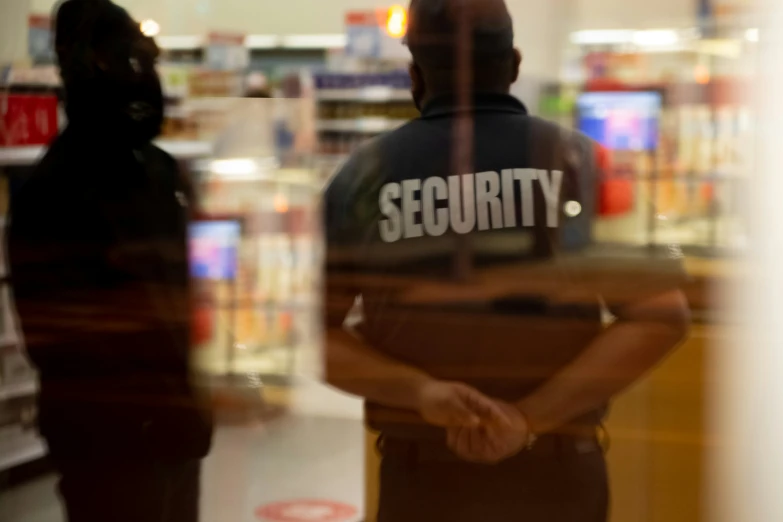 two security personnel standing in front of a security shop