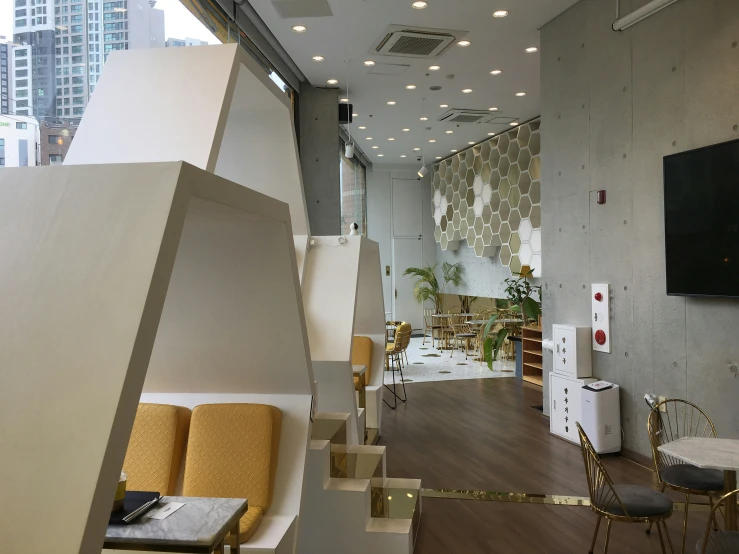 a hallway in the office building with couches, chairs and tv