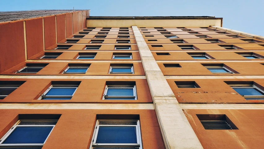 a brown building with several windows under blue sky