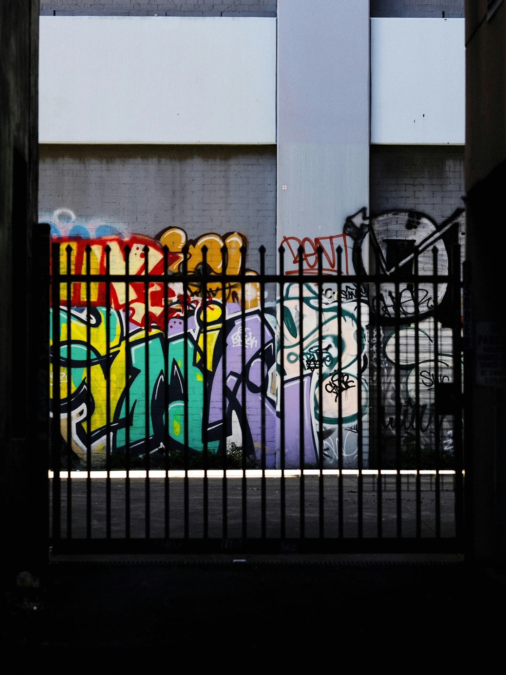 black and white po of graffiti on fence near building