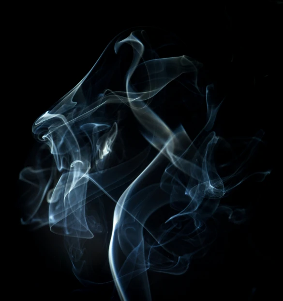 smoke is seen as it has been formed into a black background