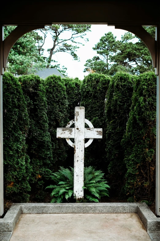 a cross in the center of some bushes