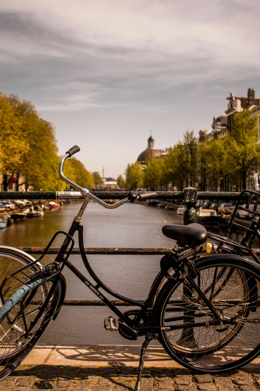 two bikes leaning on the bars of a bridge