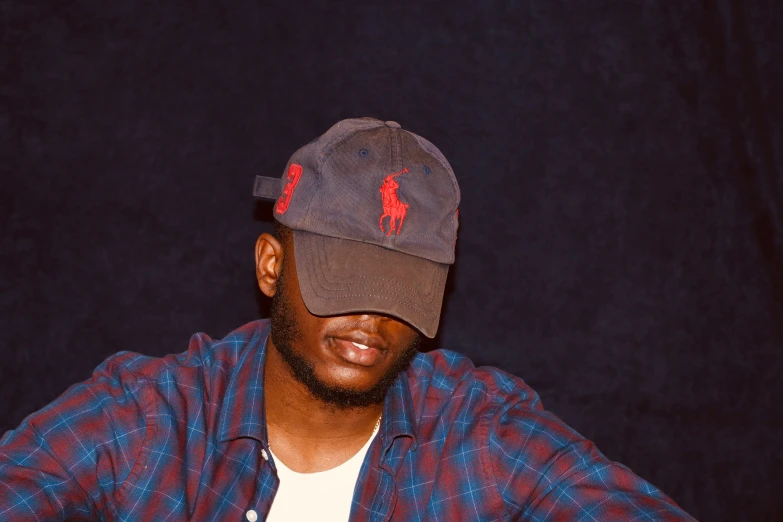 a man wearing a hat, plaid shirt and jeans