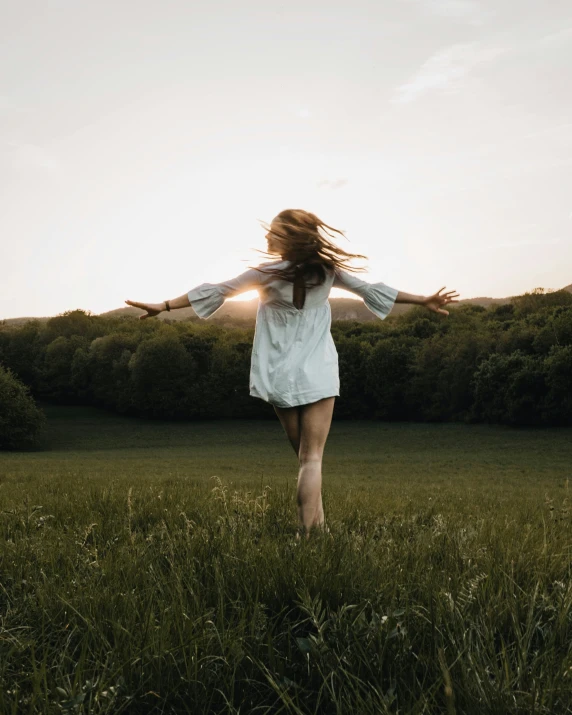 a woman standing on top of a lush green field