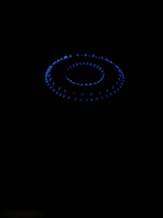 a glowing disc in the dark with the light from the top