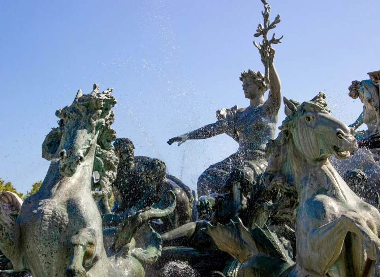 fountains splash water on horses as people ride them