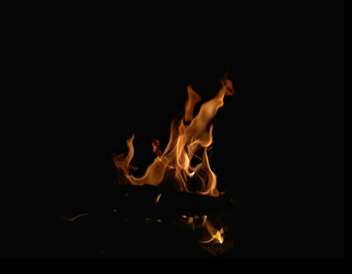 a close - up s of fire in the dark with light on the surface