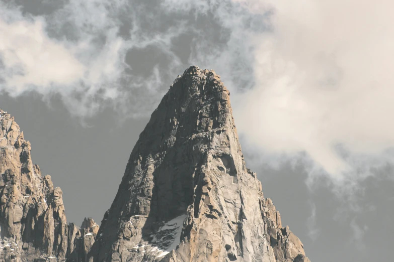 a mountain peak is shown against a cloudy sky