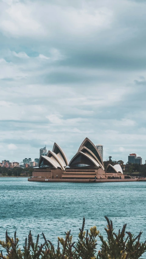 a building sitting in the middle of water near a city