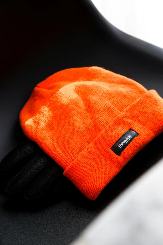 an orange knit hat sitting on top of a table