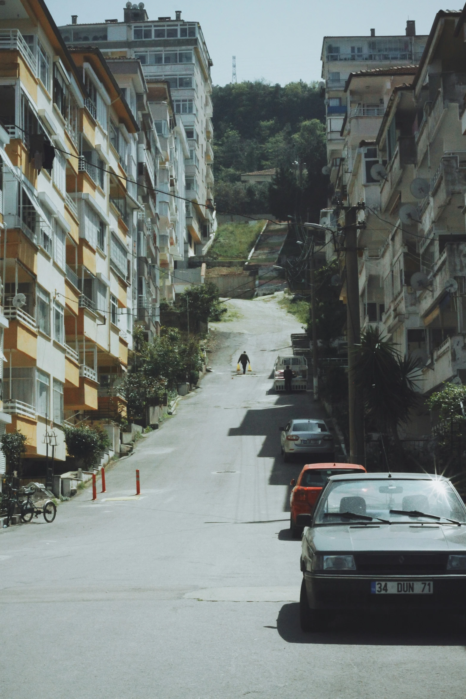 a man walking across a street between several buildings