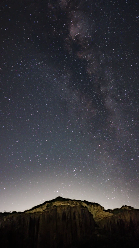 a mountain range under stars at night