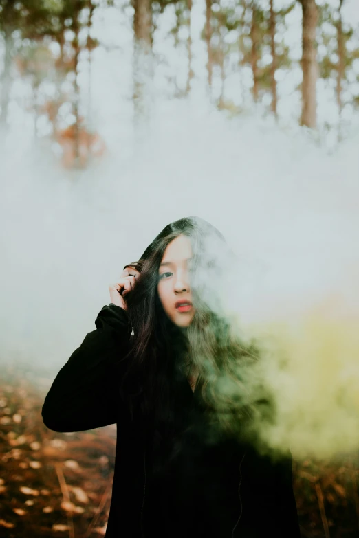 a girl in a black coat in the woods