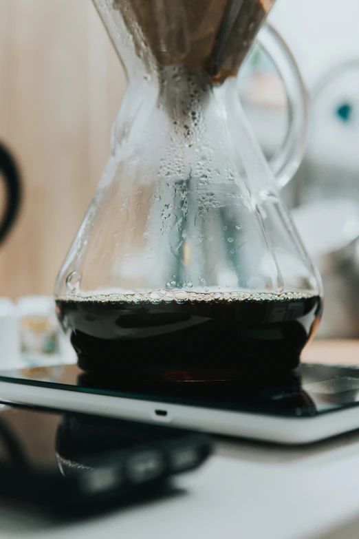 a coffee pot with some liquid being poured