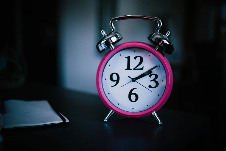 an alarm clock that is on top of a desk