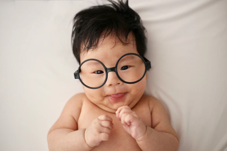 a baby with round glasses on his face