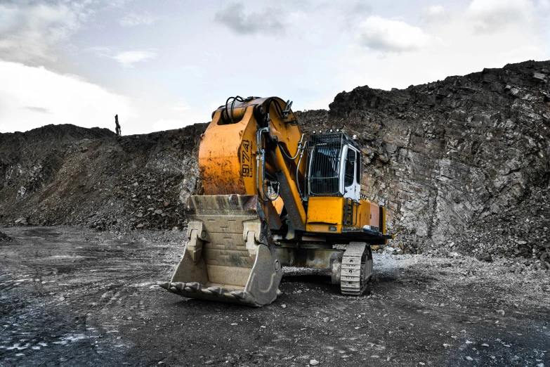 the large bulldozer is in front of a dirt hill