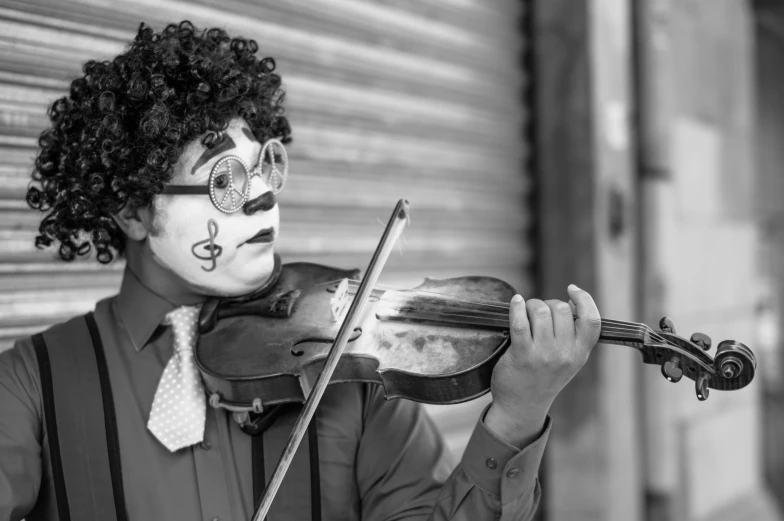 a clown playing the violin as he waits