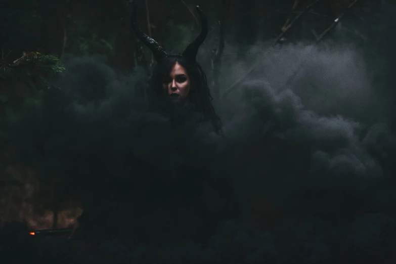 a woman with horns and dark hair surrounded by clouds