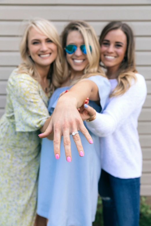 three beautiful women posing for a picture in front of a building