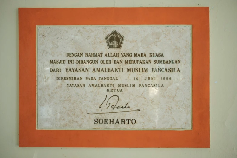 a plaque in a red frame on the wall