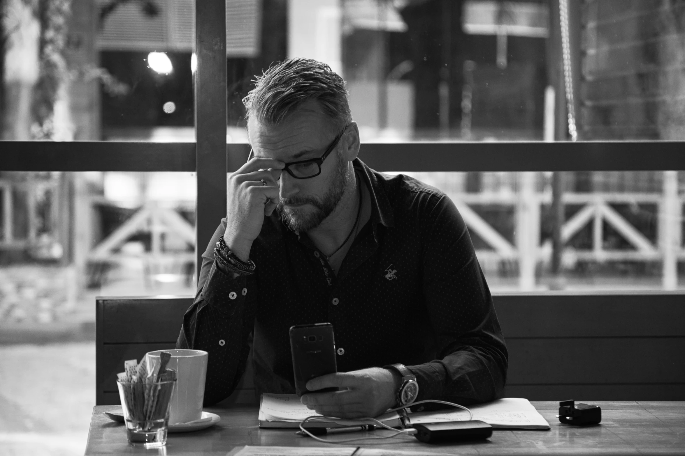 a man sitting at a table talking on his cell phone