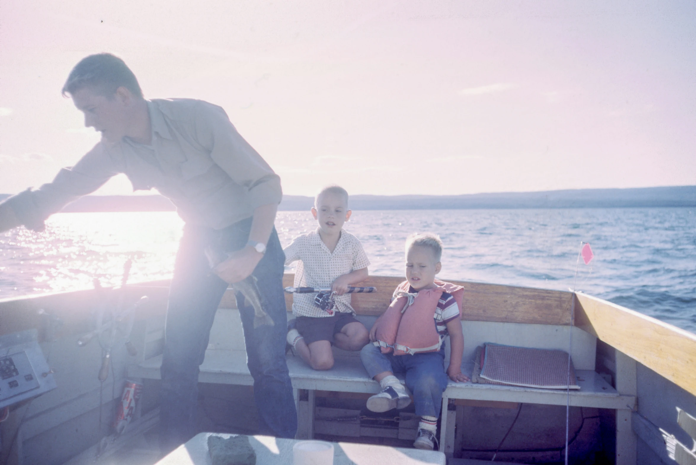 two small children sit on the edge of a boat