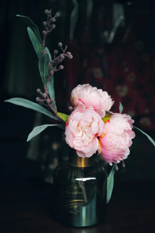 pink peonies in a clear vase on a table