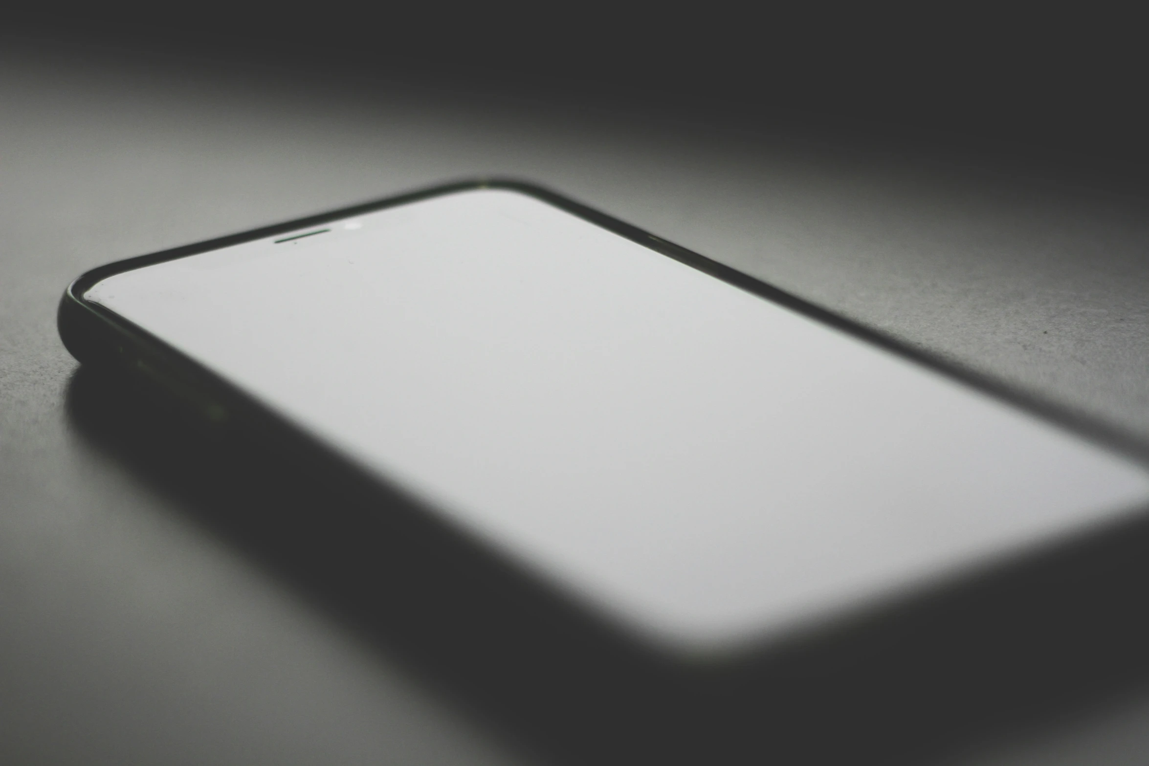 a cell phone sitting on a table in black and white