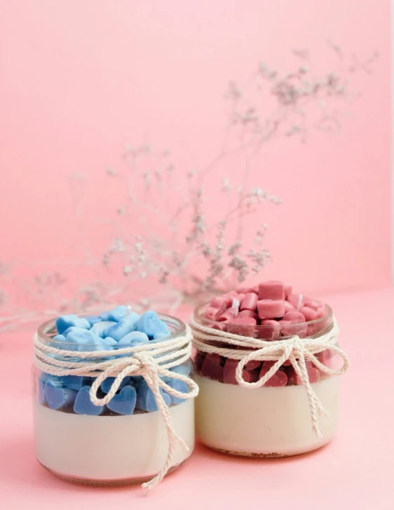 two glass jars with colorful candies and white rope tied around them